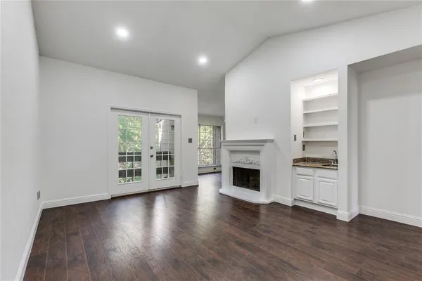 a view of an empty room with a fireplace and a window