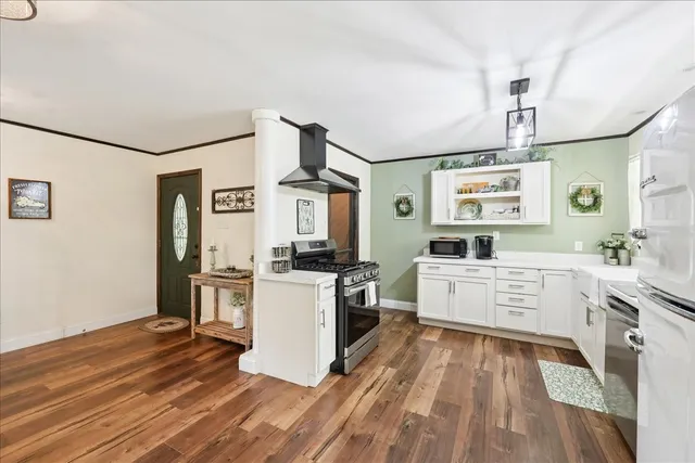 a kitchen with a sink wooden floor and white cabinets