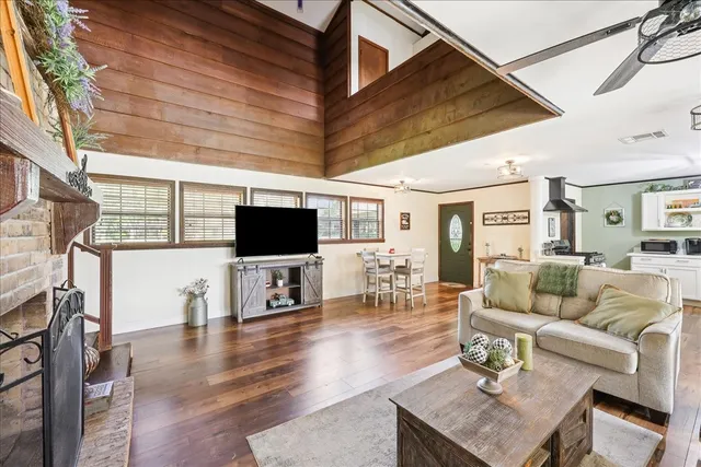 a living room with furniture a flat screen tv and a fireplace