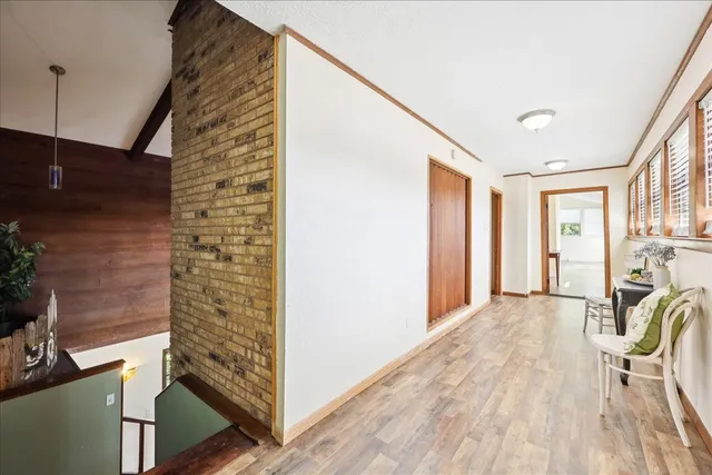a view of a hallway with wooden floor and staircase