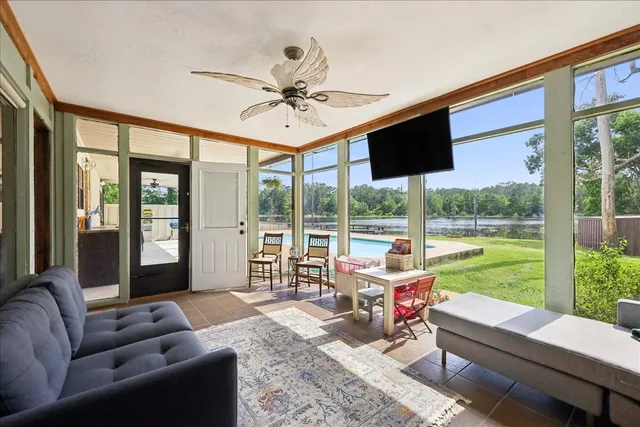 a living room with furniture and floor to ceiling windows