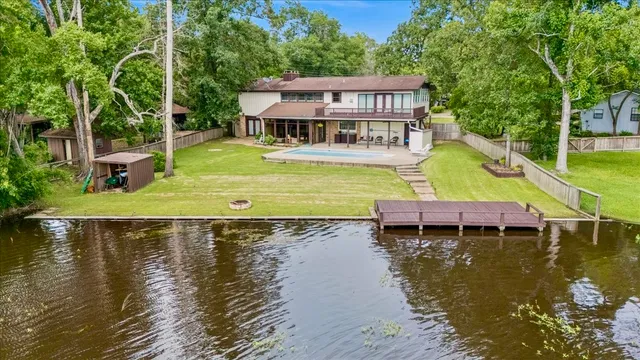an aerial view of a house with swimming pool and a yard