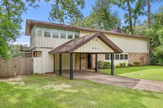 a view of a house with a yard and tree