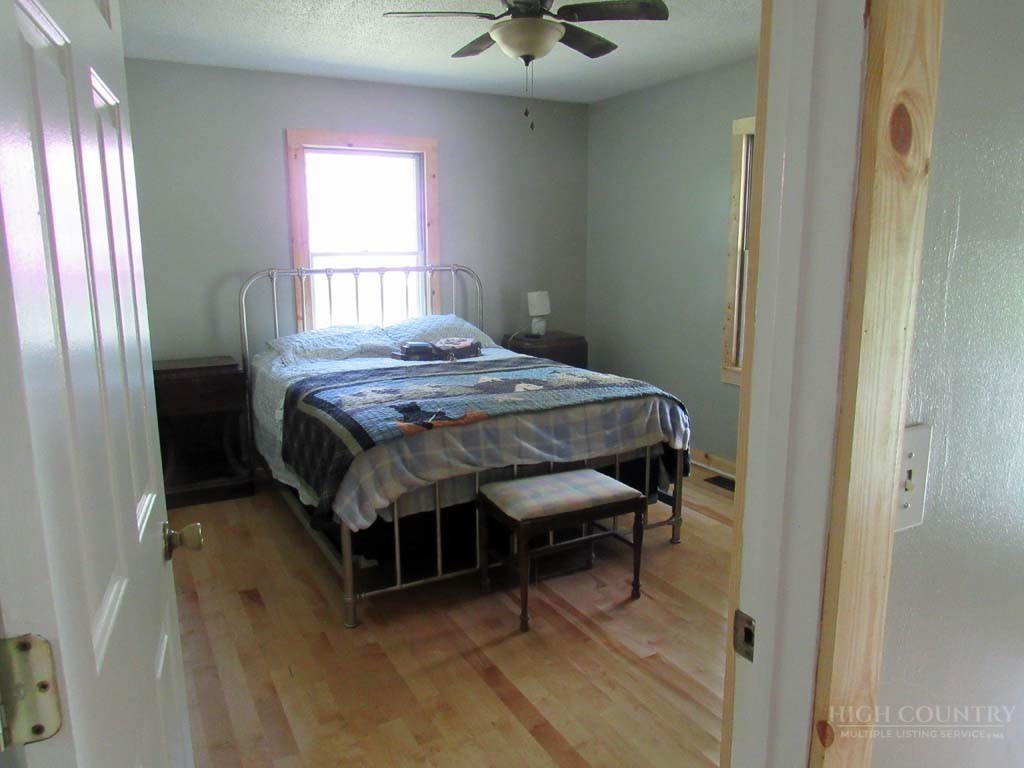 805 Ed Little Road Warrensville, NC 28693 - Photo 38 of 49 a bedroom with a bed and a chandelier