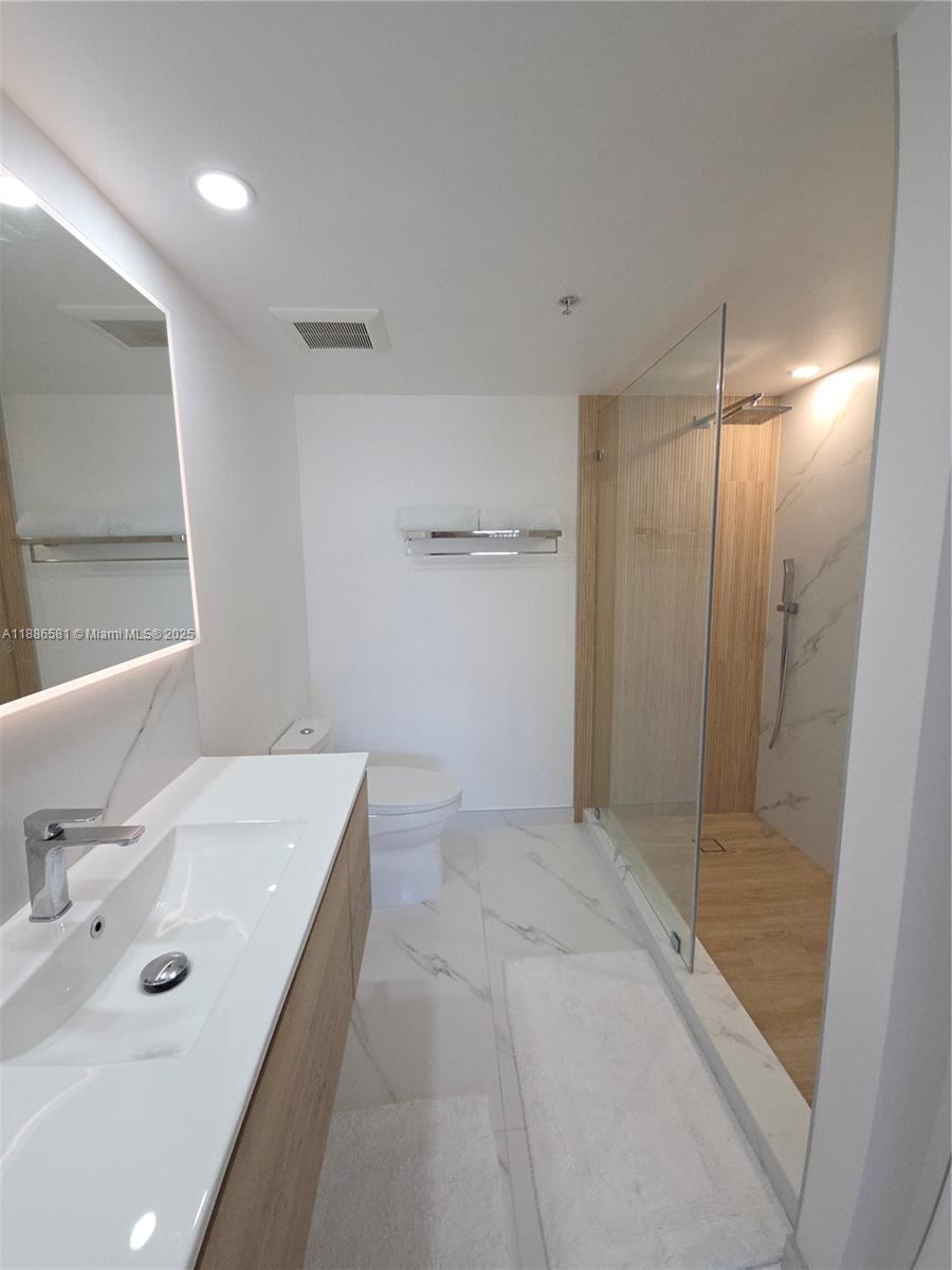 36 Northwest 6th Avenue, Unit TS9 Miami, FL 33128 - Photo 39 of 50 a bathroom with a tub sink and mirror