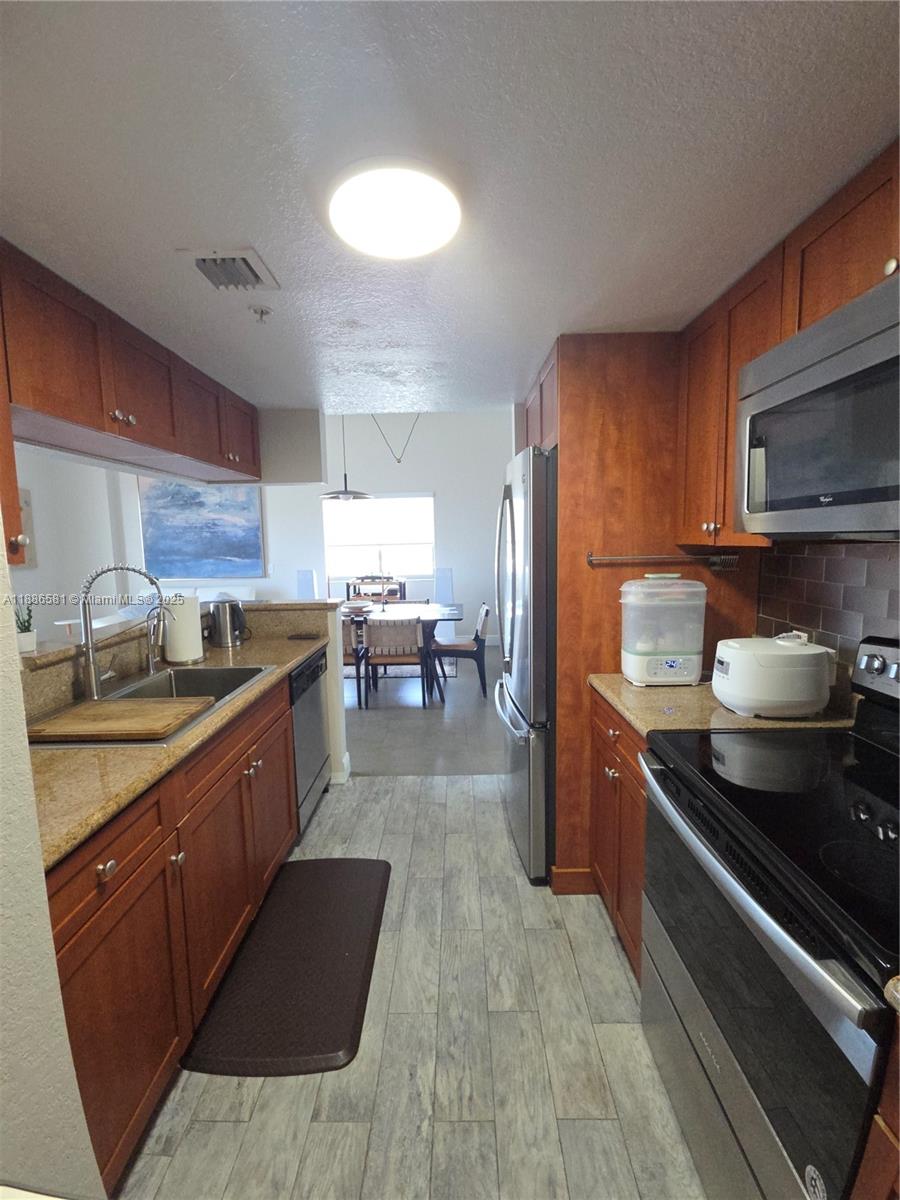 36 Northwest 6th Avenue, Unit TS9 Miami, FL 33128 - Photo 42 of 50 a kitchen with stainless steel appliances granite countertop a stove a sink and a refrigerator