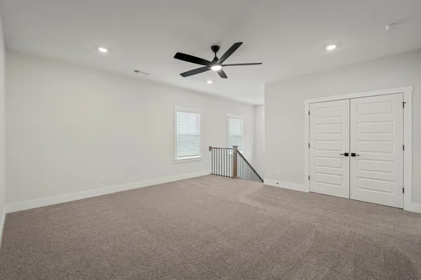 an empty room with closet and windows