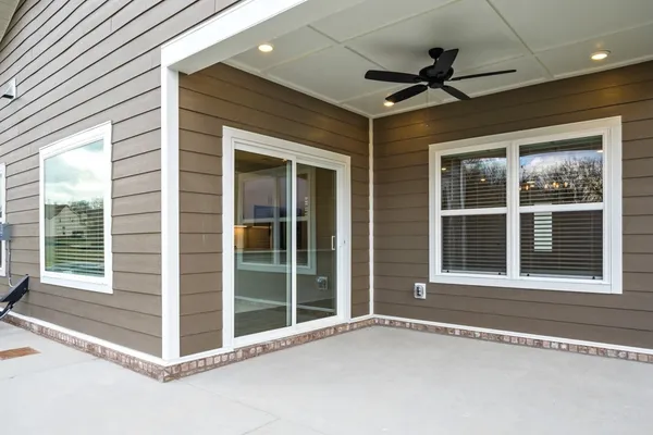 a view of an empty room with a window and a ceiling fan