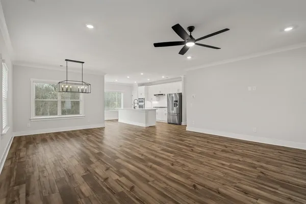 a view of a livingroom with a ceiling fan & wooden floor