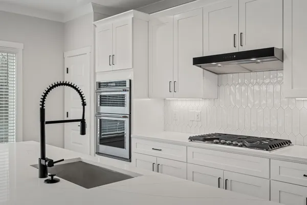 a kitchen with white cabinets and appliances