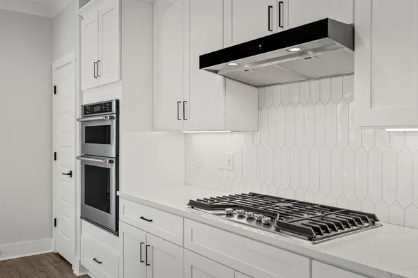 a kitchen with white cabinets and appliances
