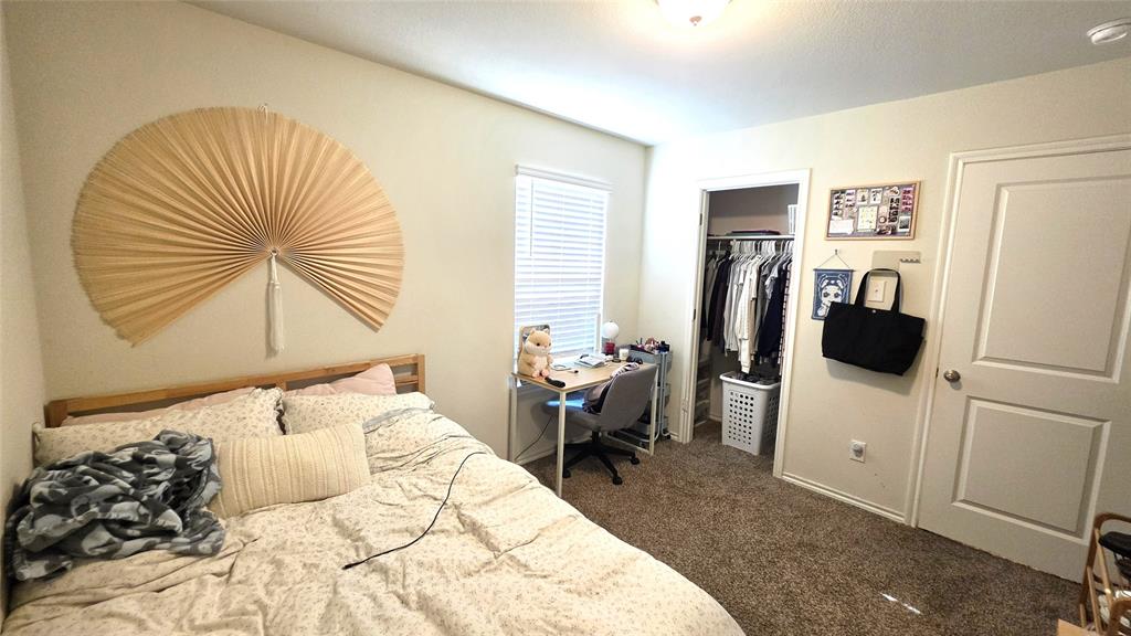 409 Samuel Street Denton, TX 76207 - Photo 9 of 40 a bedroom with a bed and a refrigerator