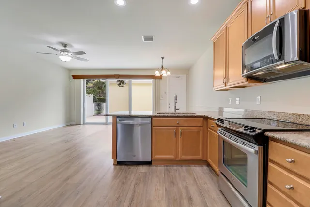 a kitchen with granite countertop a stove a sink and a refrigerator