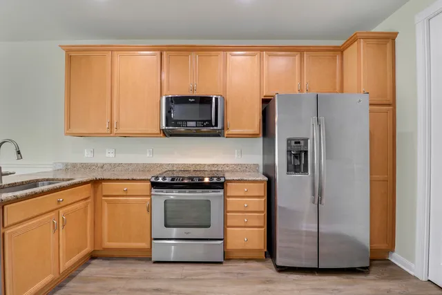 a kitchen with white cabinets and stainless steel appliances