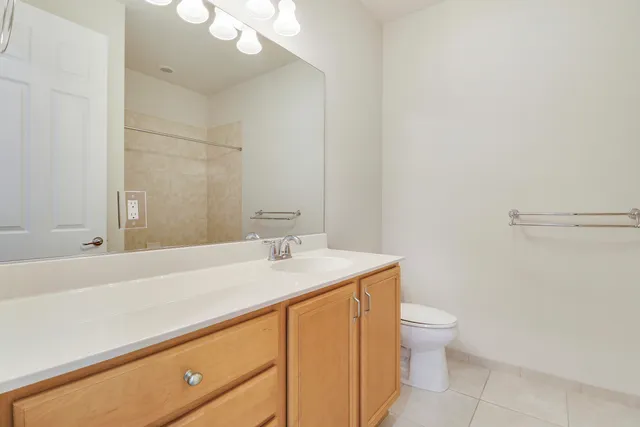a bathroom with a granite countertop sink mirror vanity and toilet