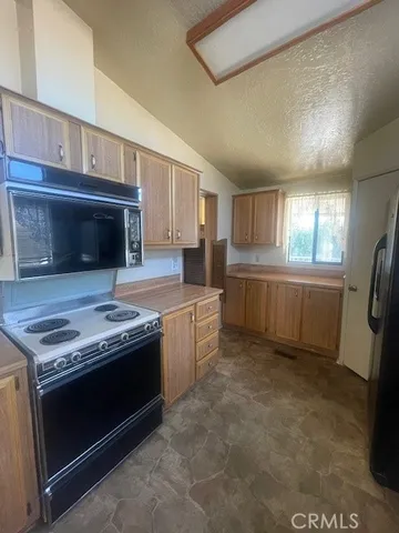 a view of a refrigerator in kitchen and a window