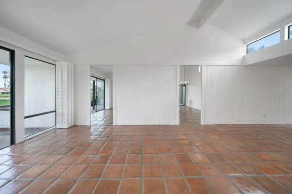 a view of a big room with wooden floor and windows