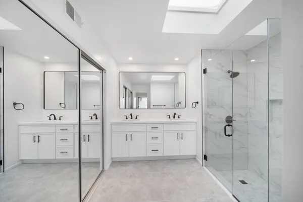 a bathroom with a shower a sink and mirror