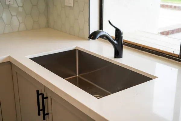 a kitchen with stainless steel appliances granite countertop a refrigerator a stove and a sink