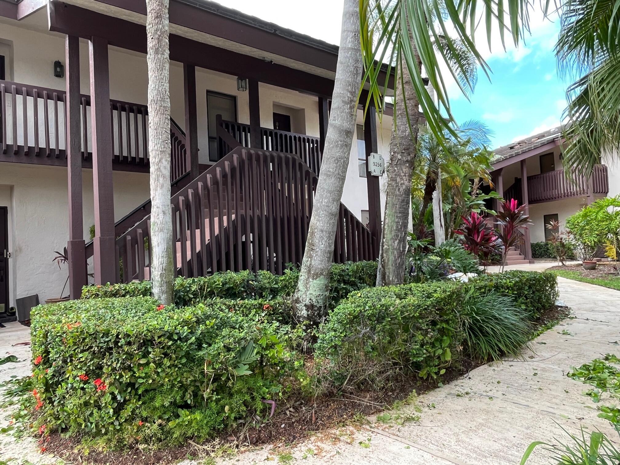 9256 Sable Ridge Circle, Unit D Boca Raton, FL 33428 - Photo 14 of 16 a view of a house with a small yard and plants