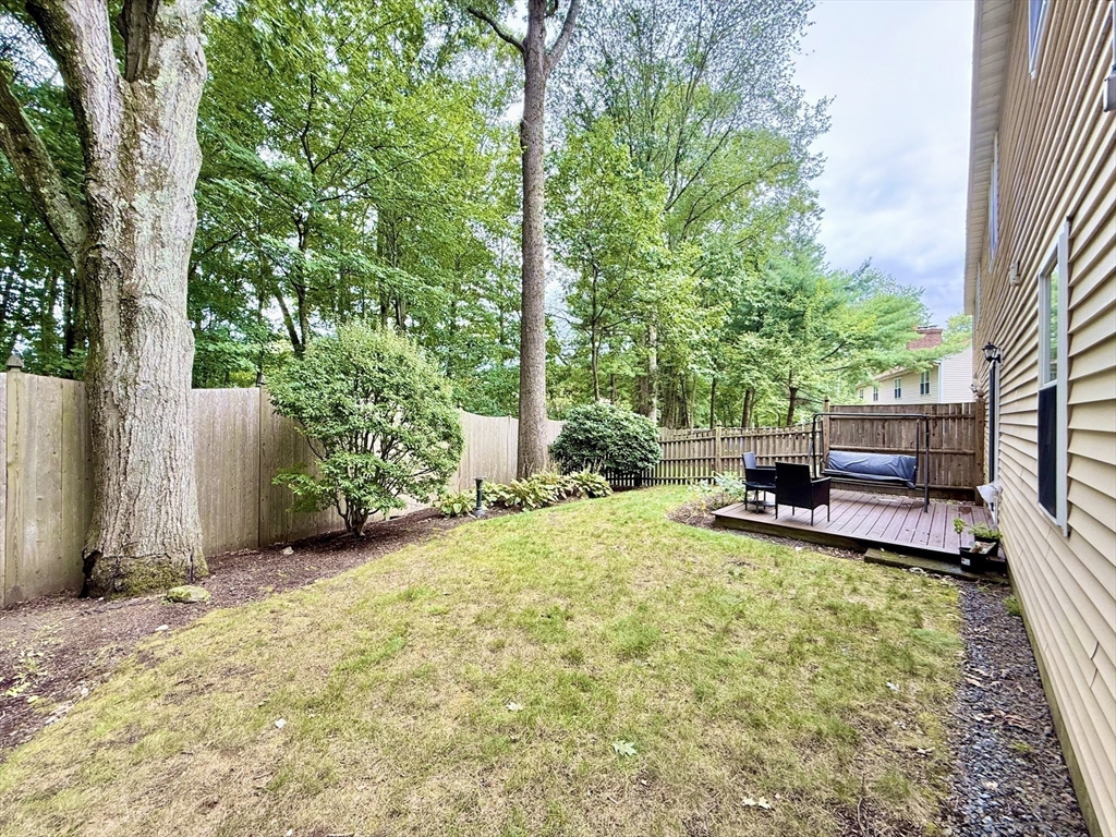 25 Homeward Lane, Unit 25 Natick, MA 01760 - Photo 16 of 16 a view of backyard with a table and chairs and potted plants