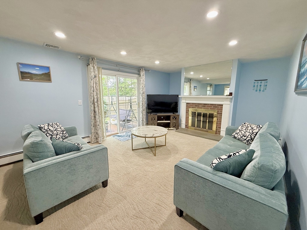 25 Homeward Lane, Unit 25 Natick, MA 01760 - Photo 2 of 16 a living room with furniture and a fireplace