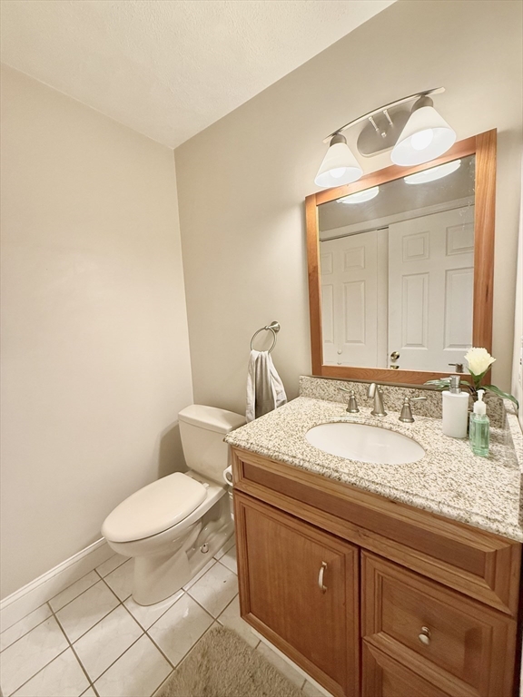 25 Homeward Lane, Unit 25 Natick, MA 01760 - Photo 9 of 16 a bathroom with a granite countertop toilet sink and mirror