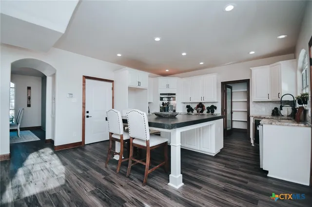 a bathroom with a granite countertop toilet a sink and a mirror