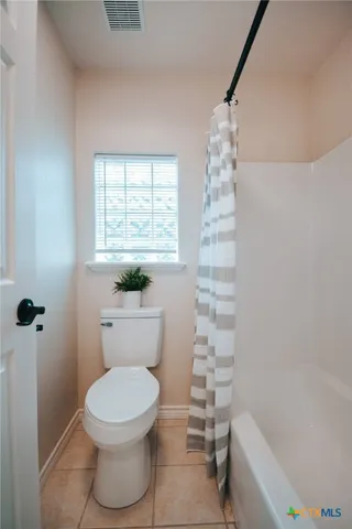 a spacious bedroom with a bed and a chandelier