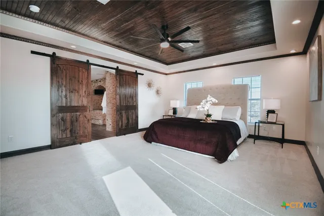 a large white kitchen with a large window appliances and cabinets
