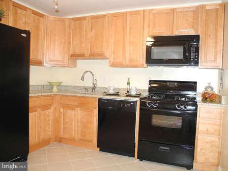 323 Leyton Road Reisterstown, MD 21136 - Photo 7 of 29 a kitchen with granite countertop a stove top oven microwave and cabinets
