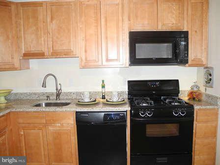 323 Leyton Road Reisterstown, MD 21136 - Photo 8 of 29 a kitchen with stainless steel appliances granite countertop a stove a microwave and a sink