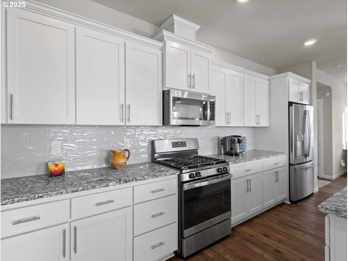 6684 North 89th Loop Camas, WA 98607 - Photo 14 of 44 a kitchen with stainless steel appliances white cabinets and a granite counter tops