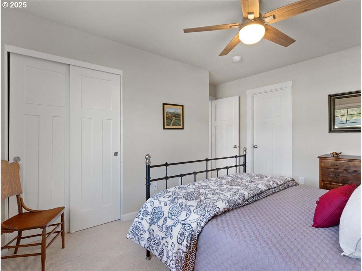 6684 North 89th Loop Camas, WA 98607 - Photo 19 of 44 a bedroom with a bed and a chandelier