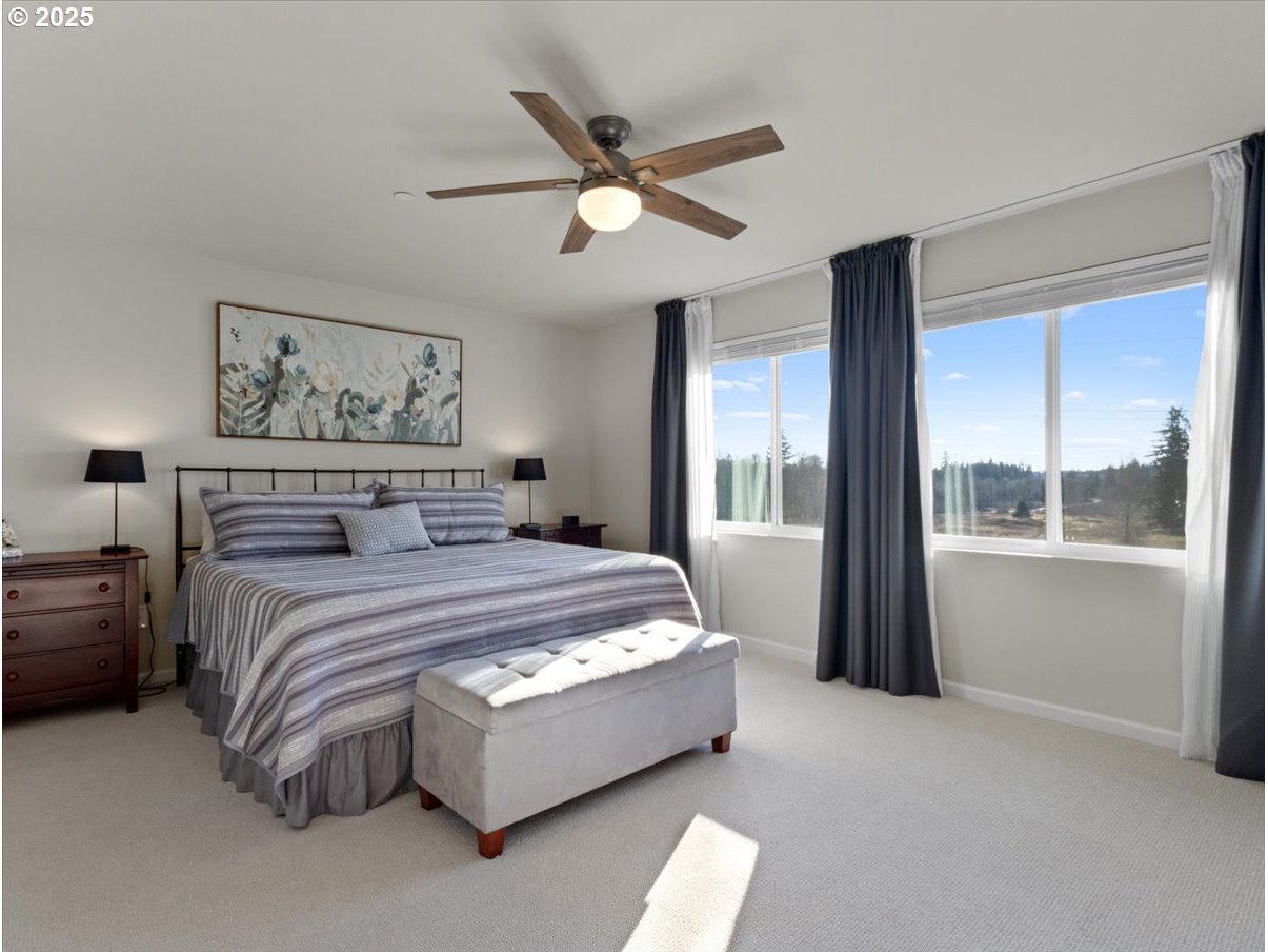 6684 North 89th Loop Camas, WA 98607 - Photo 24 of 44 a spacious bedroom with a large bed and a large window