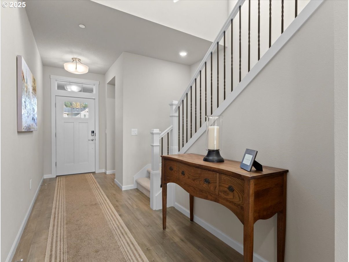 6684 North 89th Loop Camas, WA 98607 - Photo 3 of 44 a view of a hallway with wooden floor and staircase