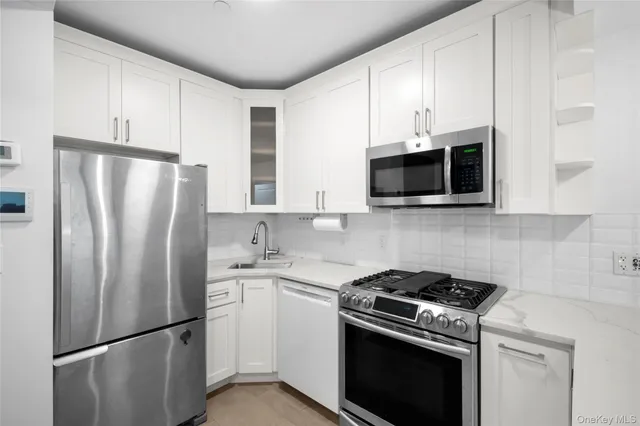 a kitchen with stainless steel appliances a refrigerator stove and microwave