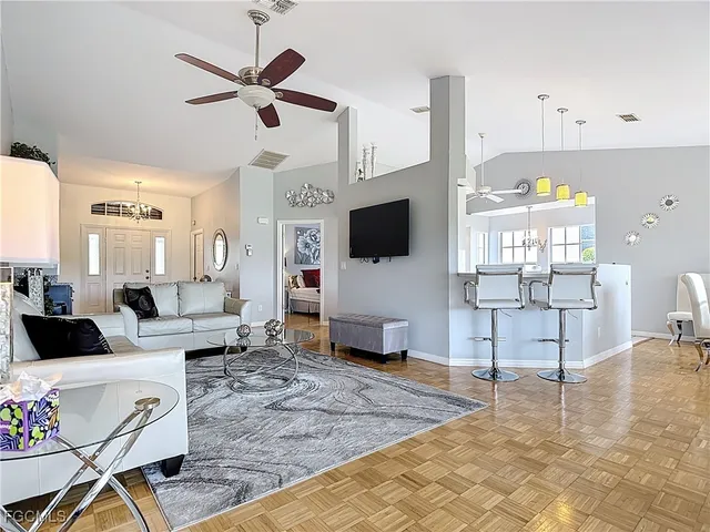 a living room with furniture a flat screen tv and a table