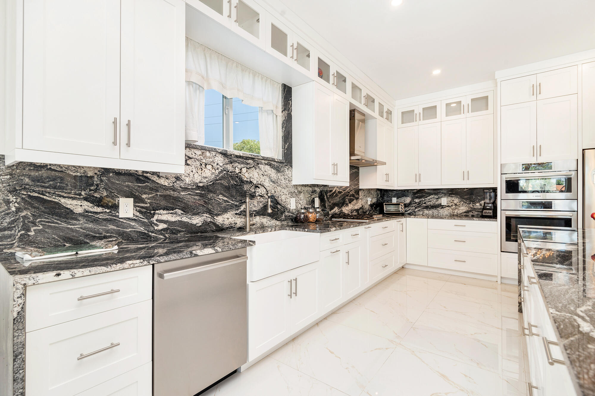 7923 Pine Tree Lane Lake Clarke Shores, FL 33406 - Photo 23 of 70 a kitchen with granite countertop white cabinets and white appliances