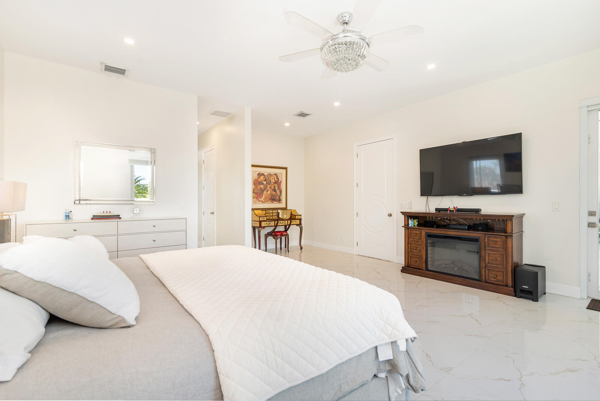 7923 Pine Tree Lane Lake Clarke Shores, FL 33406 - Photo 30 of 70 a bedroom with a large bed and a flat screen tv