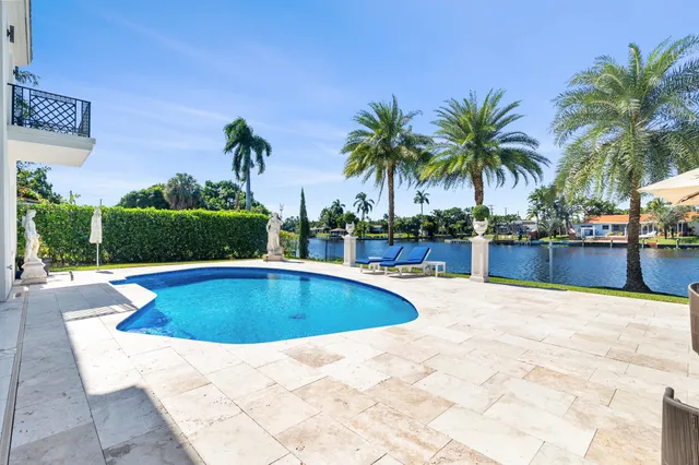 an aerial view of a house with a yard swimming pool and outdoor seating