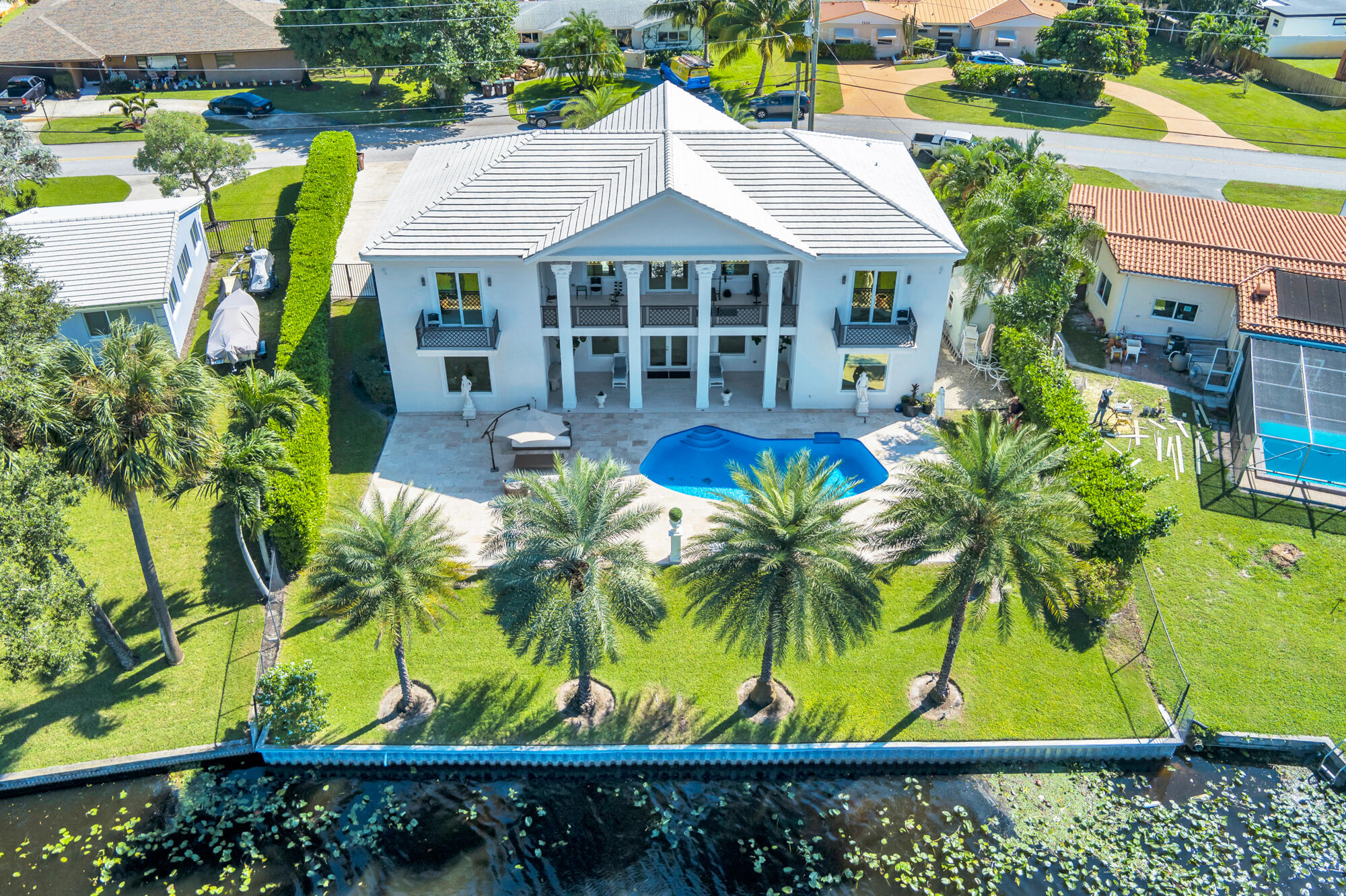 7923 Pine Tree Lane Lake Clarke Shores, FL 33406 - Photo 7 of 70 a blue swimming pool with outdoor seating and yard