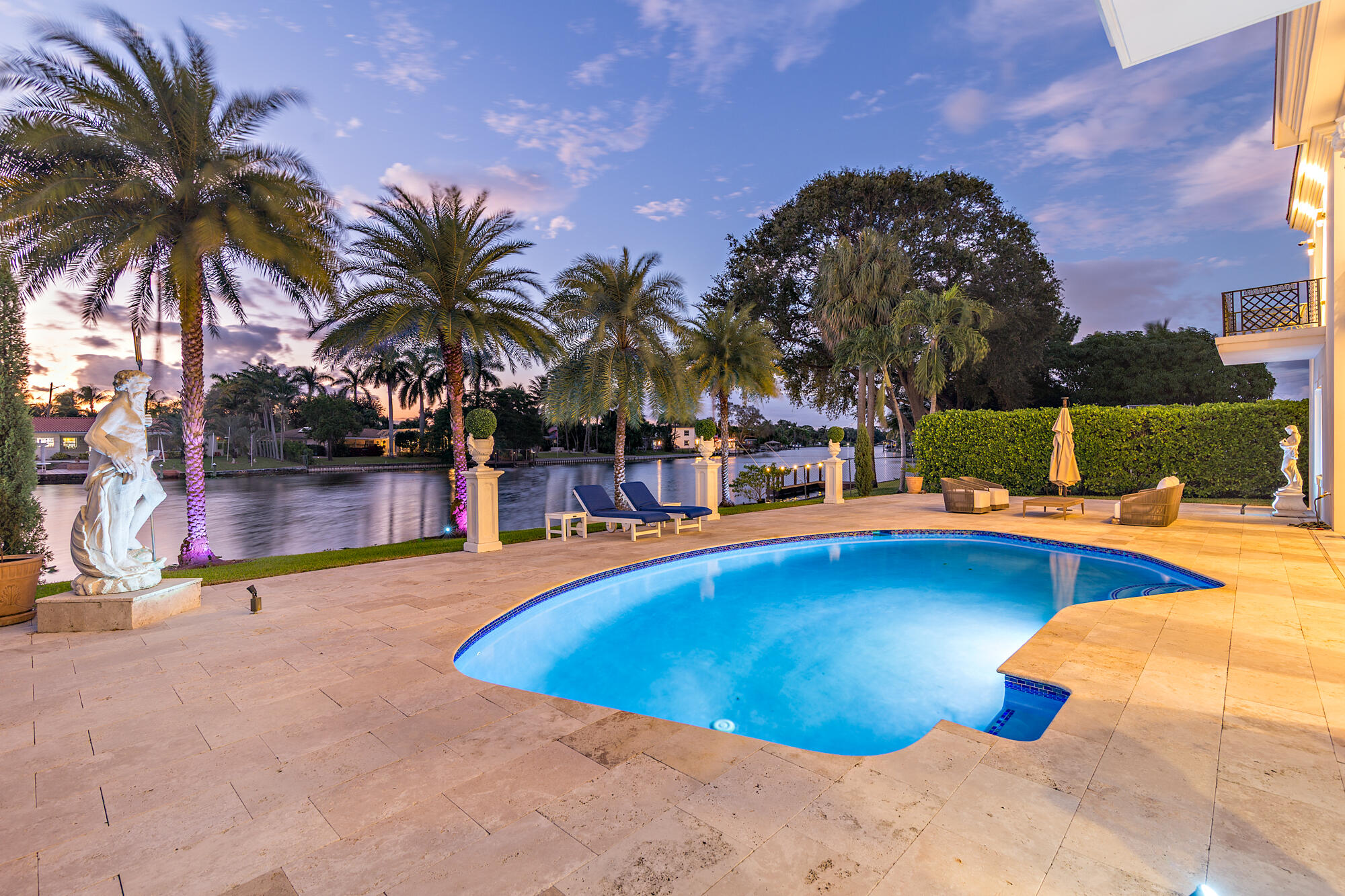 7923 Pine Tree Lane Lake Clarke Shores, FL 33406 - Photo 9 of 70 a view of a swimming pool with a lounge chair and palm trees