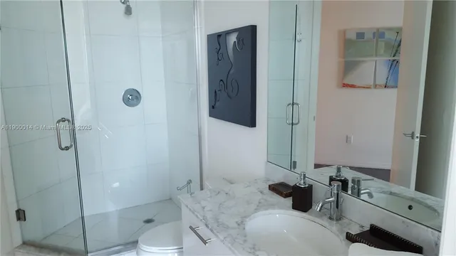 a bathroom with a sink a toilet and shower
