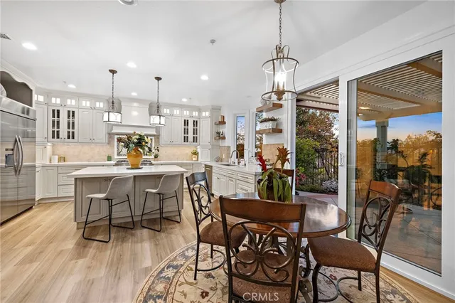 a dining room with furniture potted plants and wooden floor