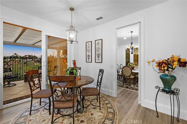 a kitchen with stainless steel appliances a dining table chairs and white cabinets