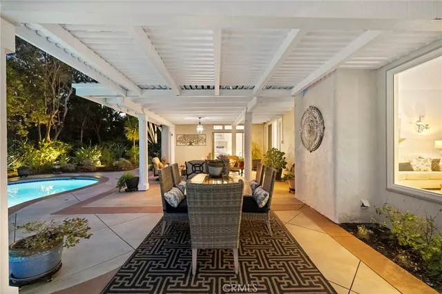 a living room with patio furniture and a floor to ceiling window