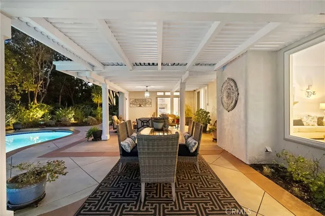 a view of a patio with table and chairs potted plants with wooden floor and fence