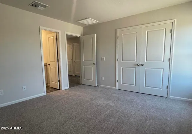 an empty room with windows and closet