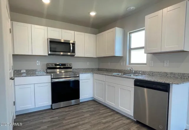 a kitchen with stainless steel appliances granite countertop a sink and a stove top oven